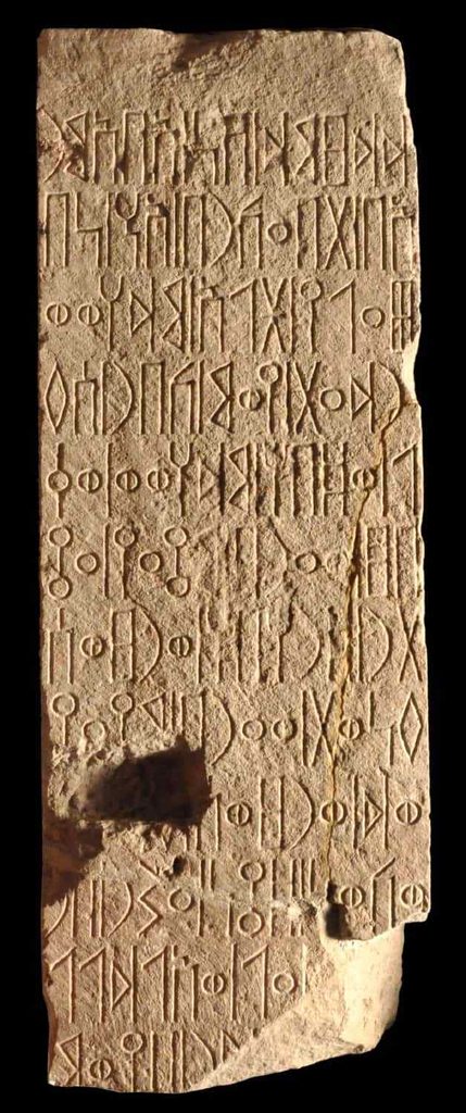 Hadramout Heritage Tours-ancient stone artifacts with carved South Arabian Musnad script displayed in a museum display case.